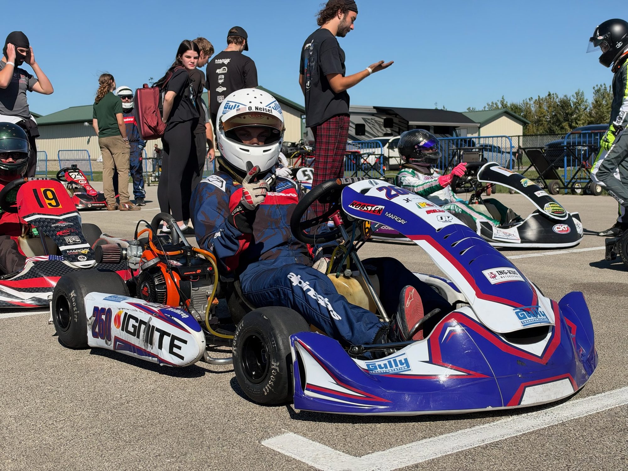 Owen Neisel giving a thumbs up from his #260 Ignite kart on the grid