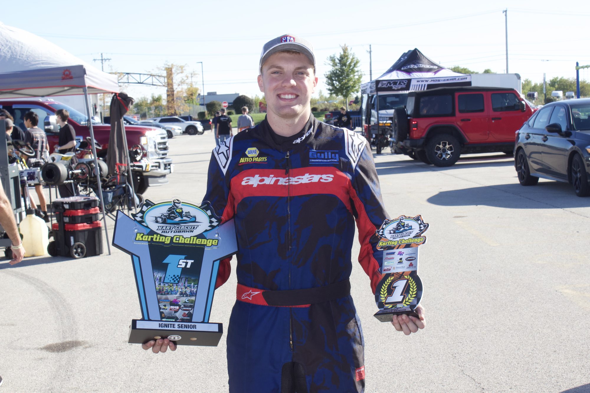 Owen Neisel holding his Ignite Senior first-place and Karting Challenge championship trophies