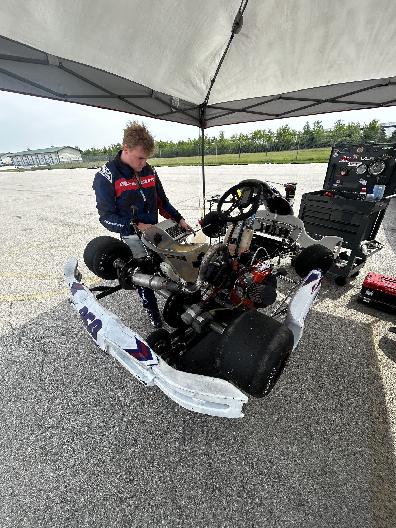 Owen Neisel reviewing data logger telemetry on his kart during a test day